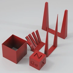 Red geometric calibration shapes for 3D printing, including cones, cubes, and angled structures.
